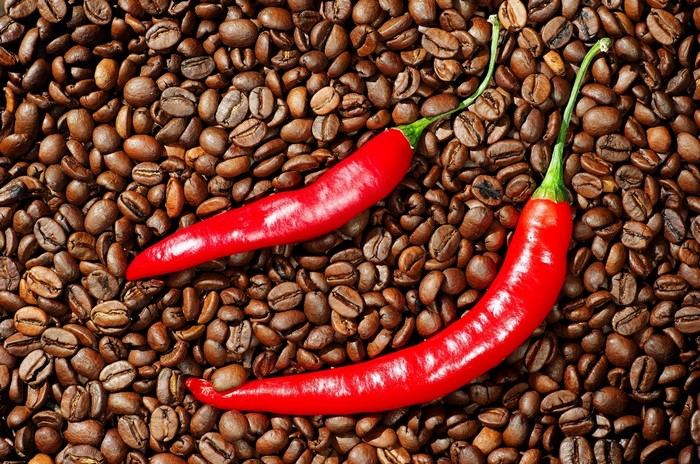 Red chili peppers on roasted coffee beans