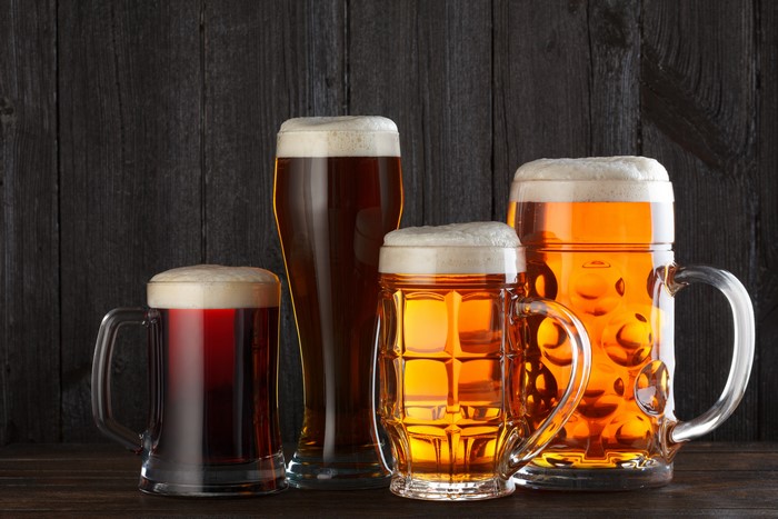 Four glasses of beer on a dark wooden background