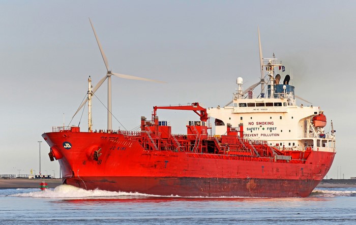 Red tanker ship JO KIRI sailing near wind turbines