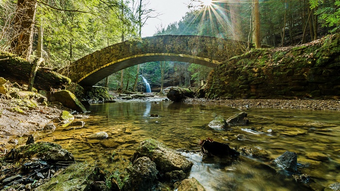 Stone bridge over a stream with a waterfall