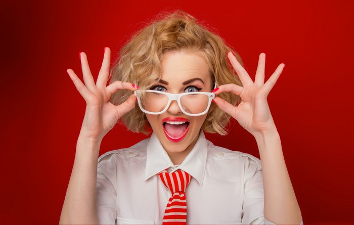 Woman with glasses and red tie on red background