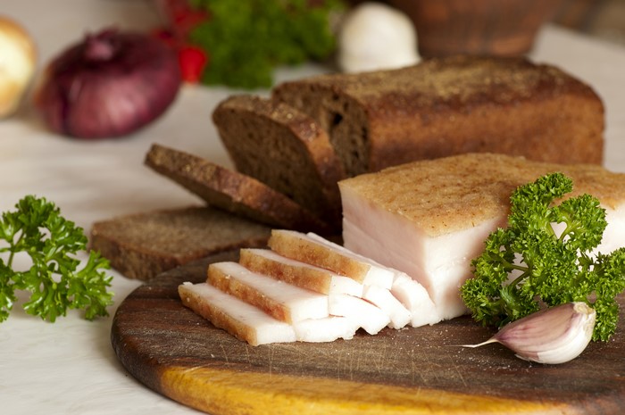 Salo, Bread, Garlic, and Parsley on a Cutting Board