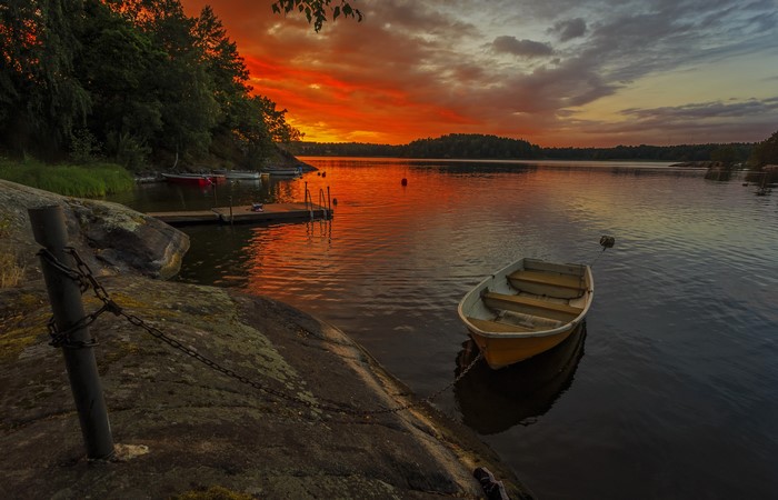Sunset over a Swedish coast with boats and a dock