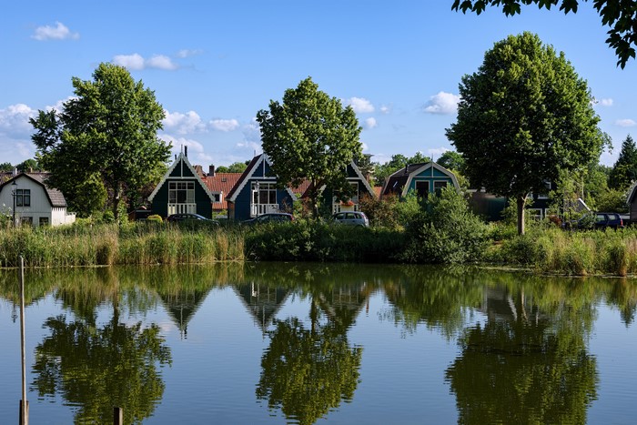 Houses and trees reflected in a river in Beverwijk, Netherlands