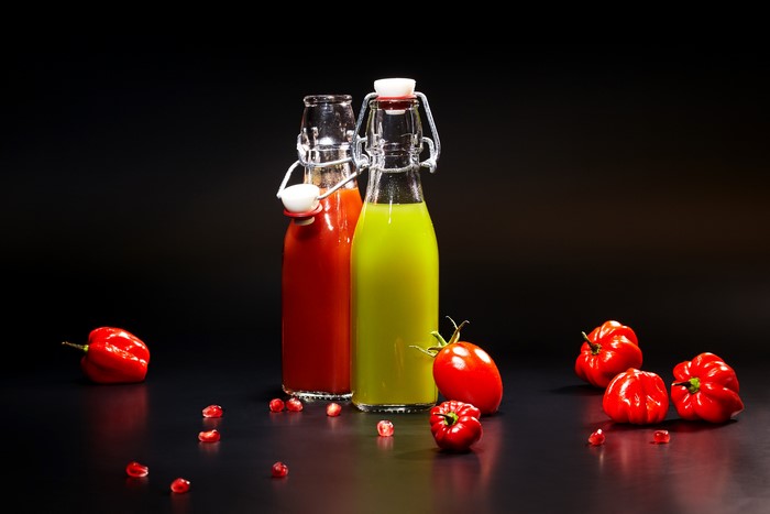 Two bottles of juice with tomatoes and peppers