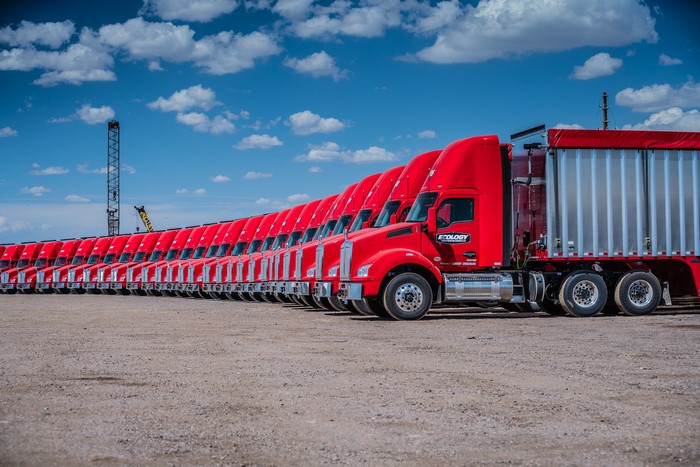 Line of red Kenworth T880 trucks parked outdoors