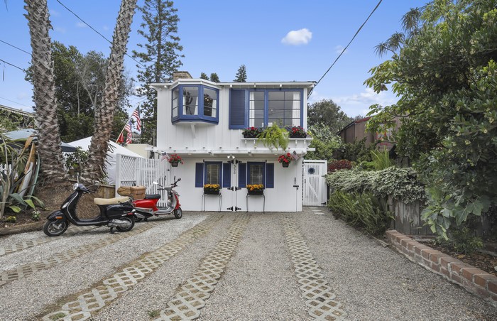 White house with blue shutters and scooters in driveway