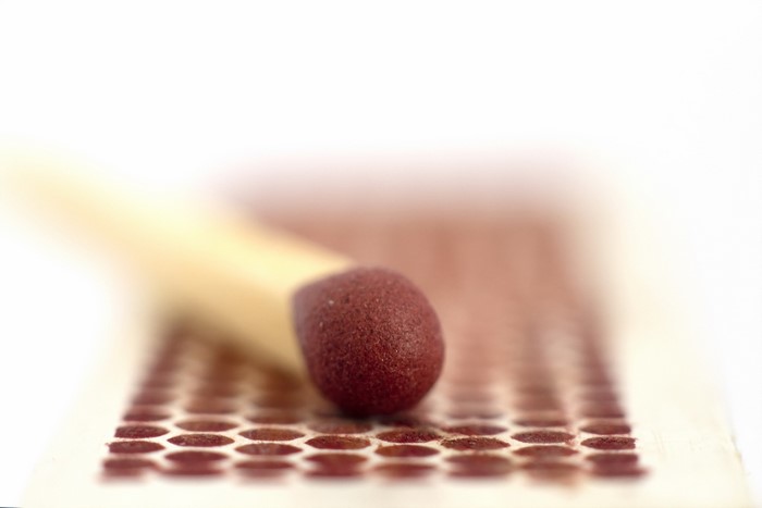 Close-up of a match head on a matchbox