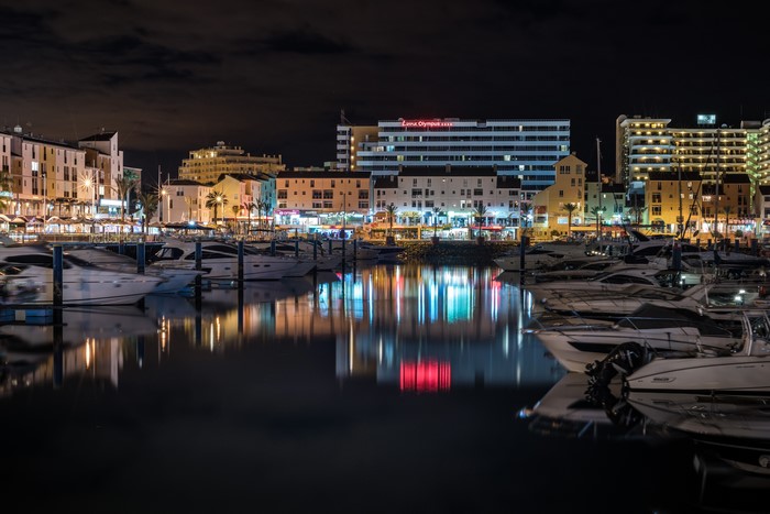 Night view of Faro Marina with yachts and buildings in Portugal