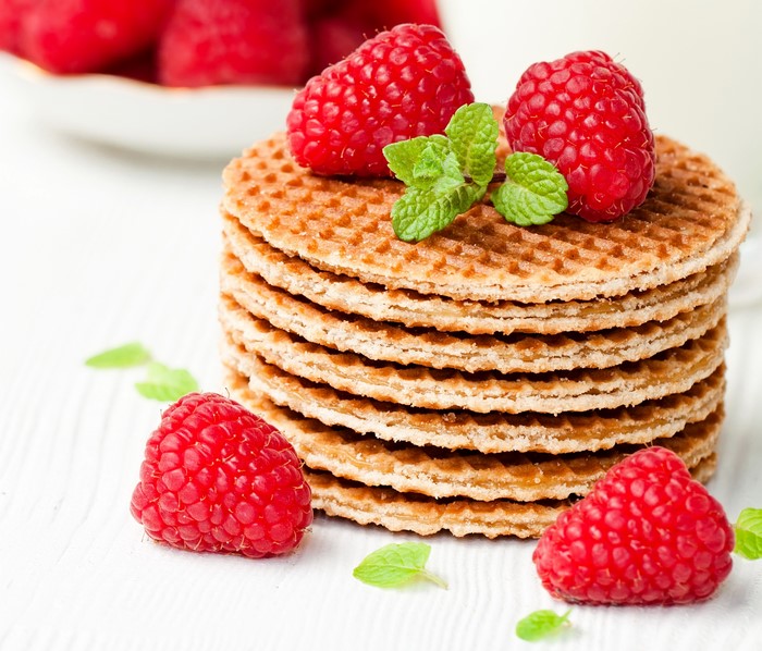 Stack of waffles with raspberries and mint leaves