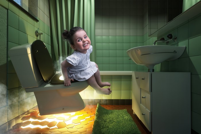 Funny Little Girl Sitting on Toilet with Steam