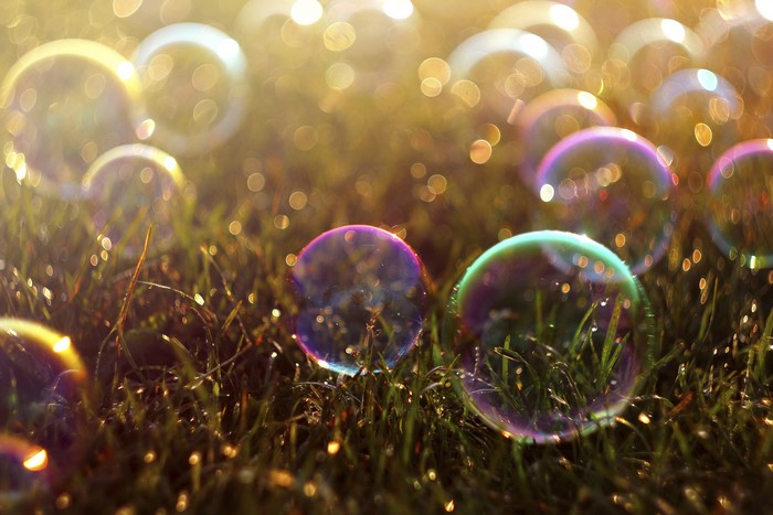 Soap bubbles on grass with bokeh lights