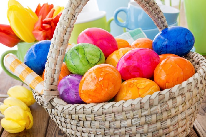 Easter eggs in a wicker basket with tulips