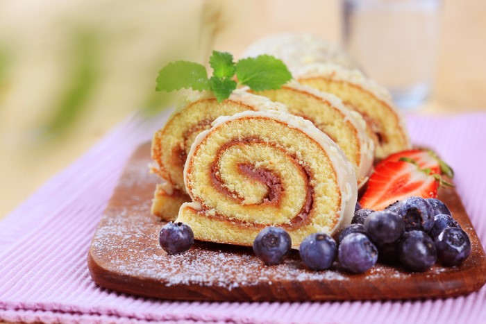Swiss roll with berries on a cutting board