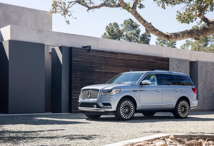 Silver 2018 Lincoln Navigator parked in front of modern house