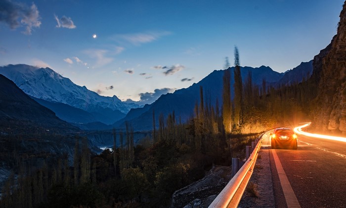 Car on a mountain road at dusk in Hunza, Pakistan