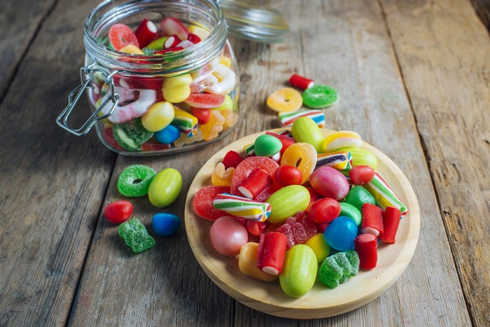 Assorted Candies in a Jar and Bowl on Wood