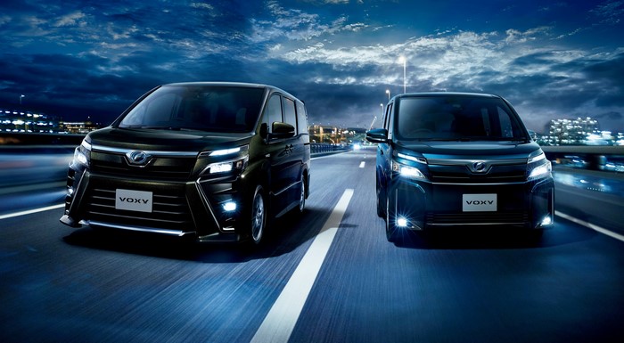 Two Toyota Voxy Cars on a Highway at Night