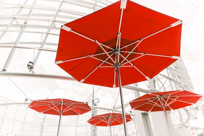 Red Umbrellas Under a Modern Structure