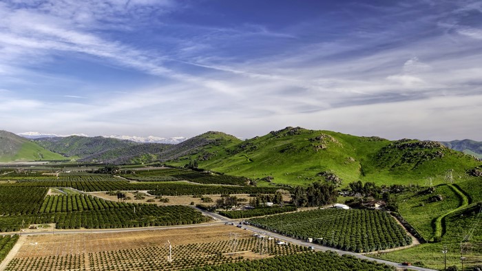 California Farmland with Rolling Green Hills and Mountains