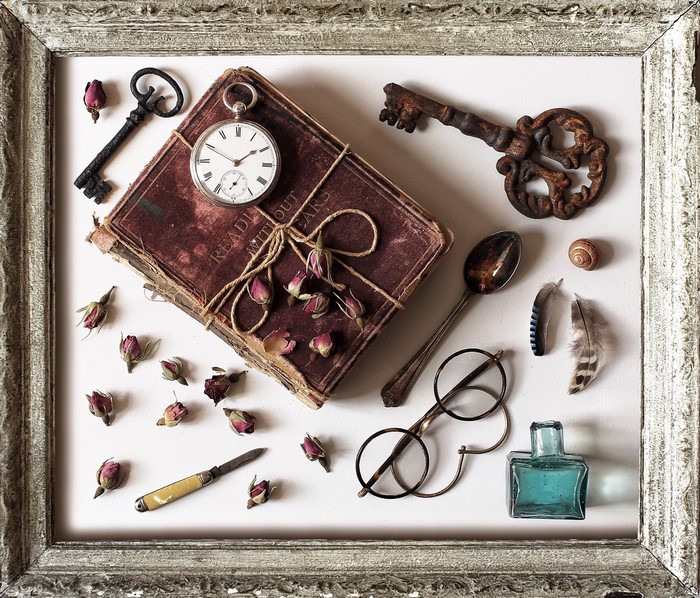 Still life with antique book, pocket watch, keys, and dried roses