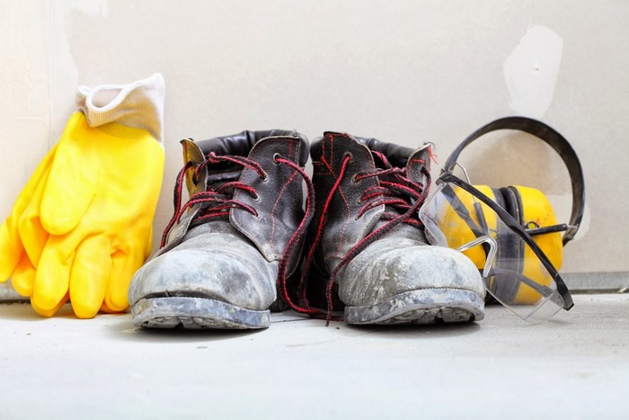 Work boots, yellow gloves, safety glasses, and headphones