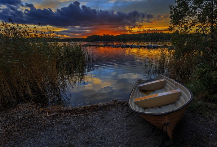 Boat on a lake at sunset with dramatic clouds