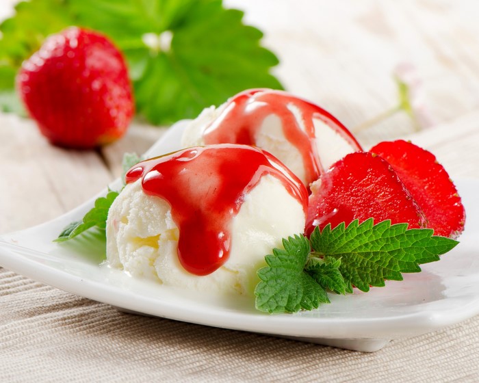 Ice cream with strawberry sauce and fresh strawberries