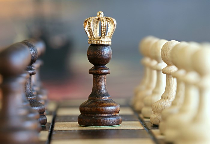 Chess king with a crown on a chessboard