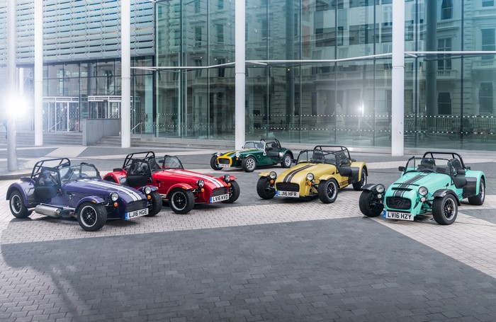 Caterham Seven cars in front of a modern building