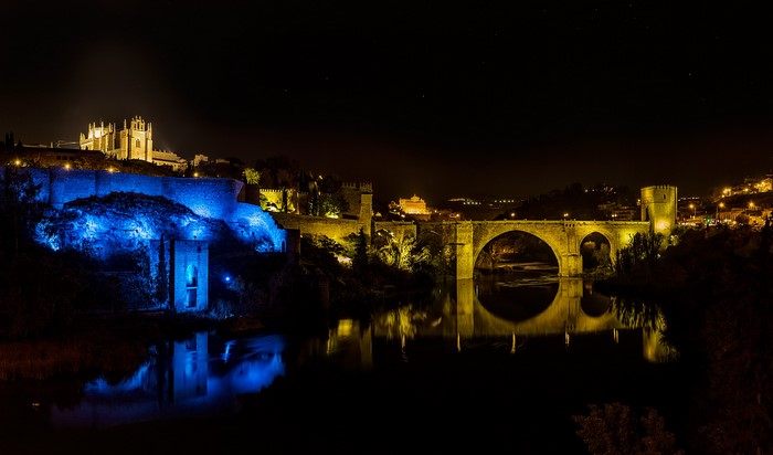 Toledo at night with illuminated bridge and castle