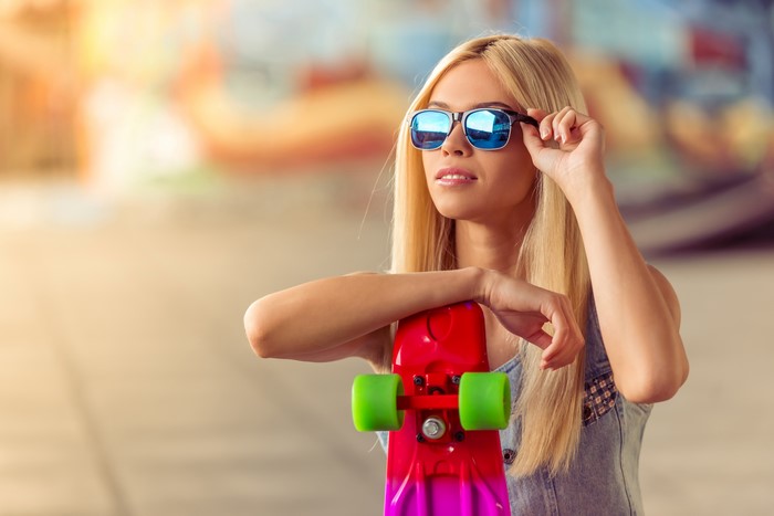 Blonde girl with sunglasses and skateboard