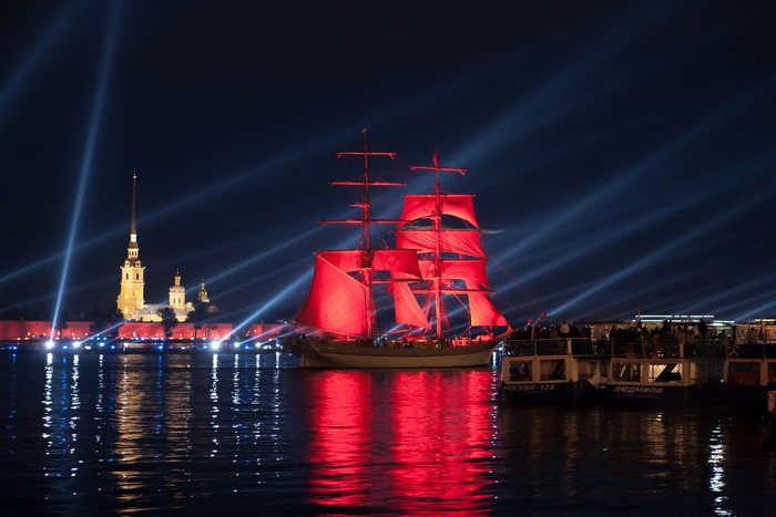 Tall ship with red sails in St. Petersburg at night