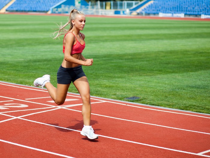 Blonde woman running on a track