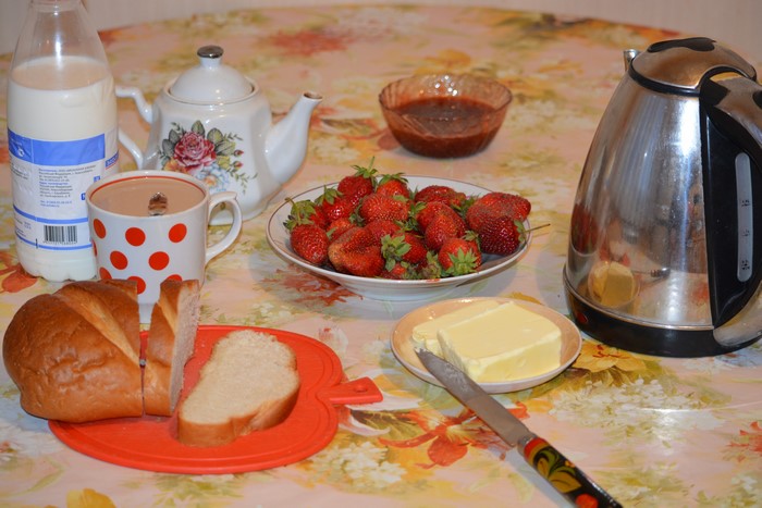 Breakfast with strawberries, bread, milk, and tea
