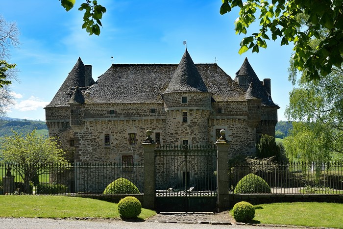 Auzers Castle in France with fence and shrubs