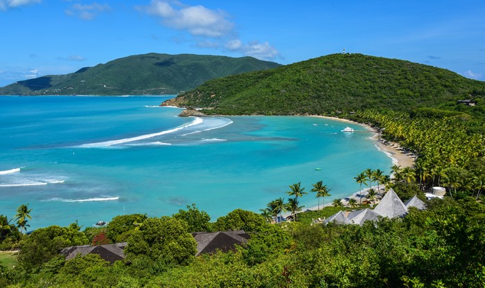 Tropical bay with green hills and palm trees