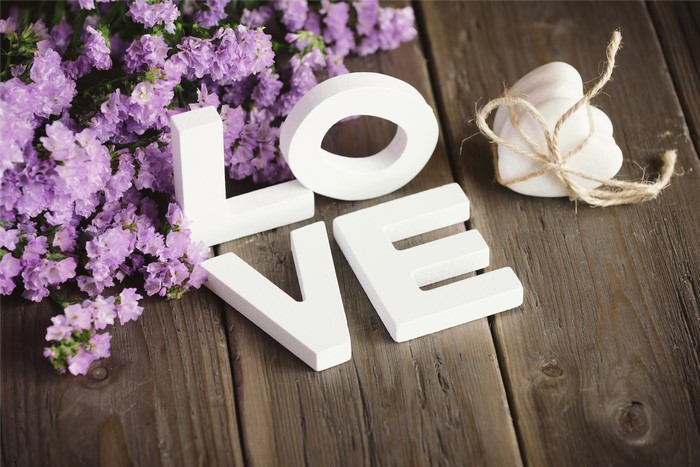 Love spelled out with white letters and purple flowers