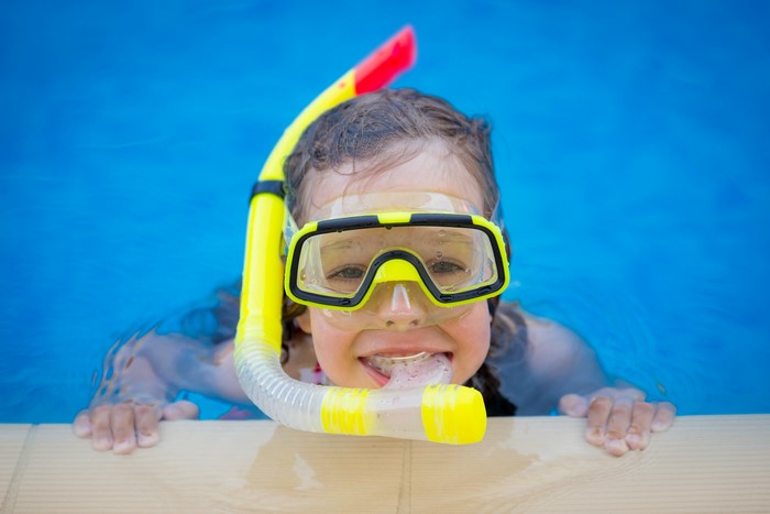 Girl with snorkel and mask in a pool
