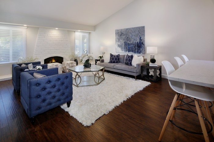 Living room with blue armchairs, gray sofa, and fireplace