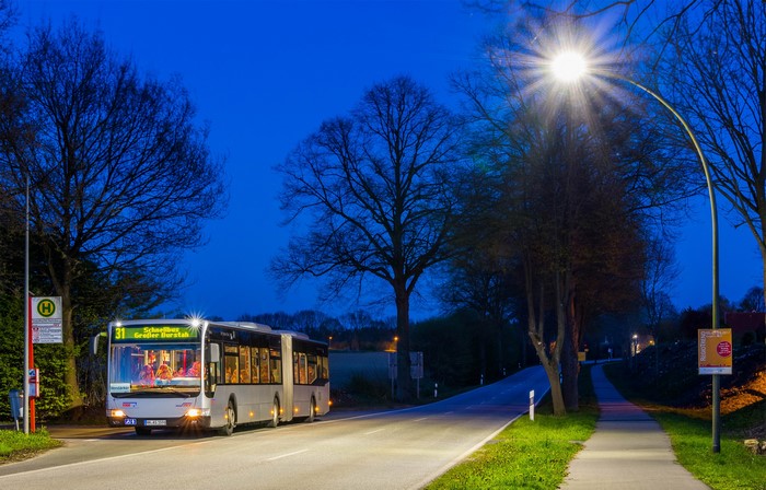 Bus at a bus stop on a road at night
