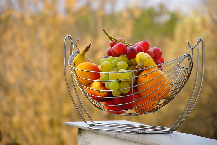 Fruit basket with grapes, apples, bananas, and oranges