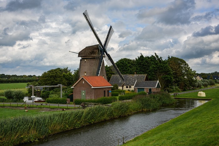 Windmill and houses in the Netherlands with a canal