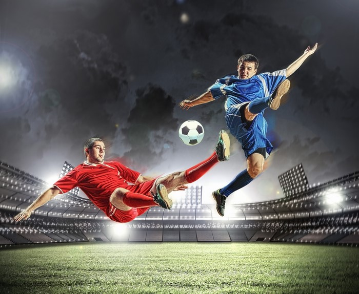 Two men playing soccer in a stadium