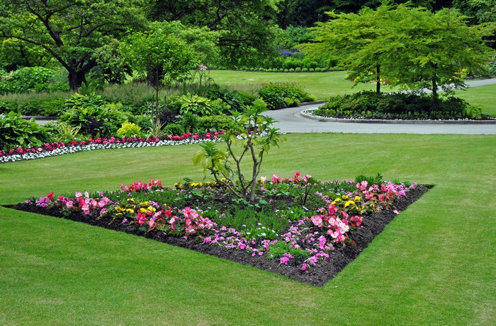 A triangular flower bed in a manicured garden