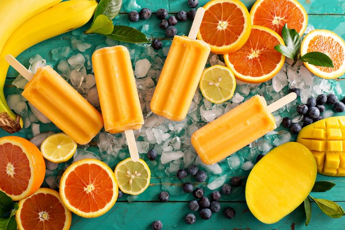 Orange popsicles with fruits and ice