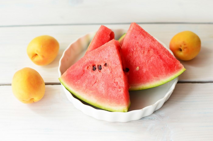Watermelon slices and apricots on a plate
