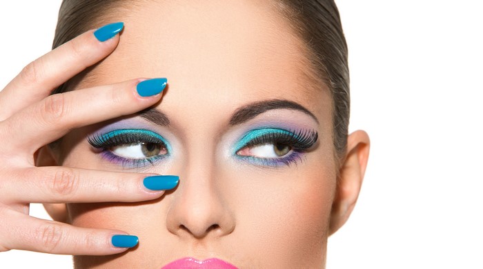 Woman with blue manicure and colorful eye makeup
