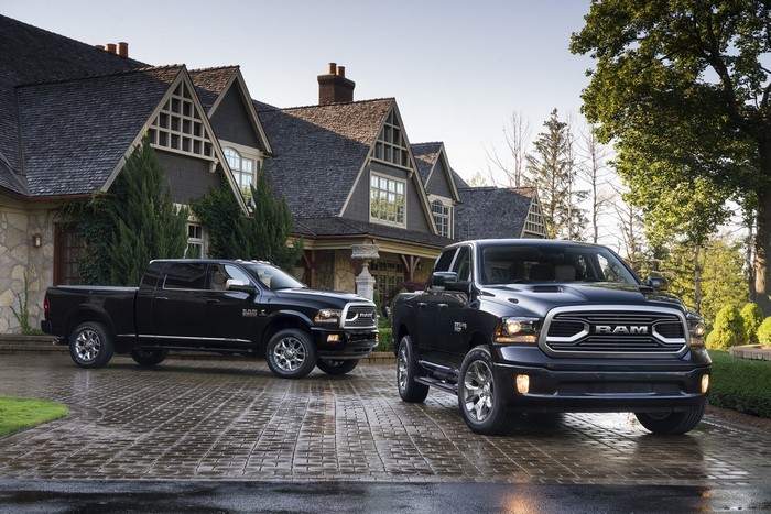 Two black Ram pickup trucks in front of a house