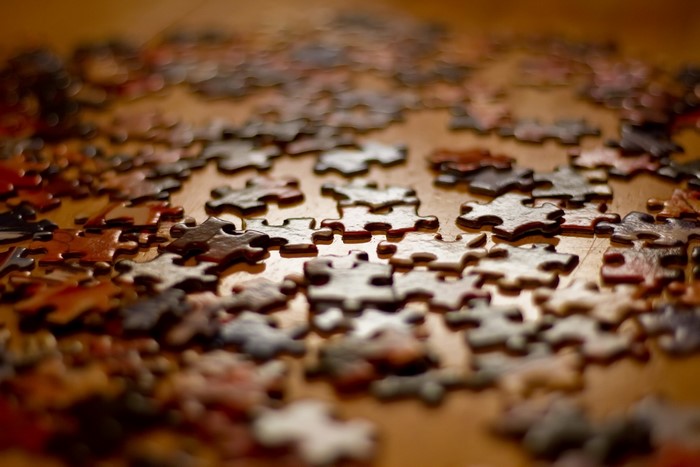 Scattered puzzle pieces on a wooden surface